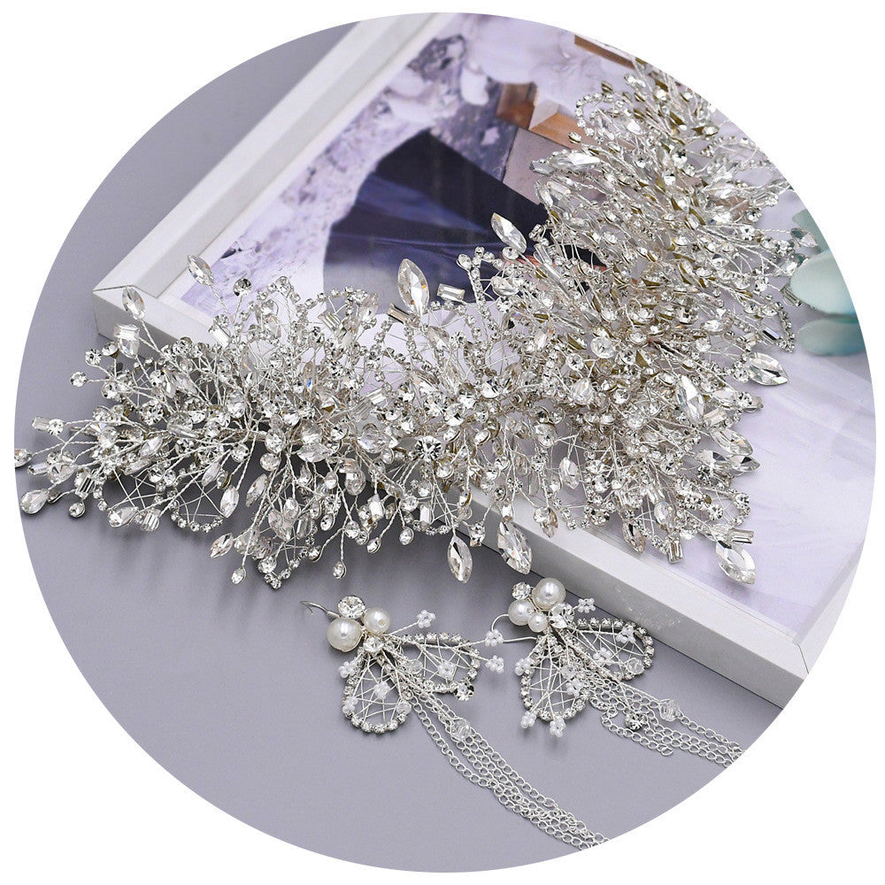 Silver hairpiece with pearls and crystals on a white surface