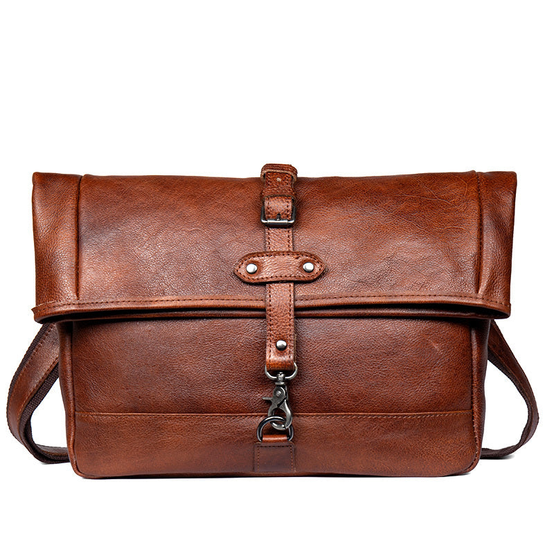 Brown leather bag with strap on a white background