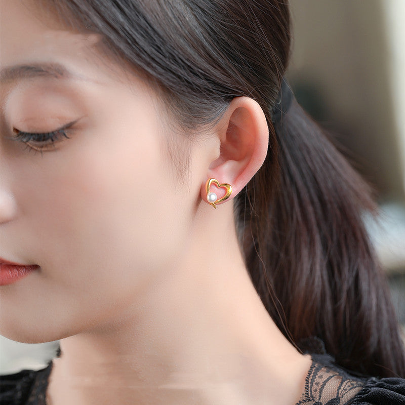 Close-up of a woman wearing heart-shaped earrings with a blurred background