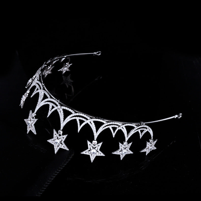 Silver tiara with star designs on a black background