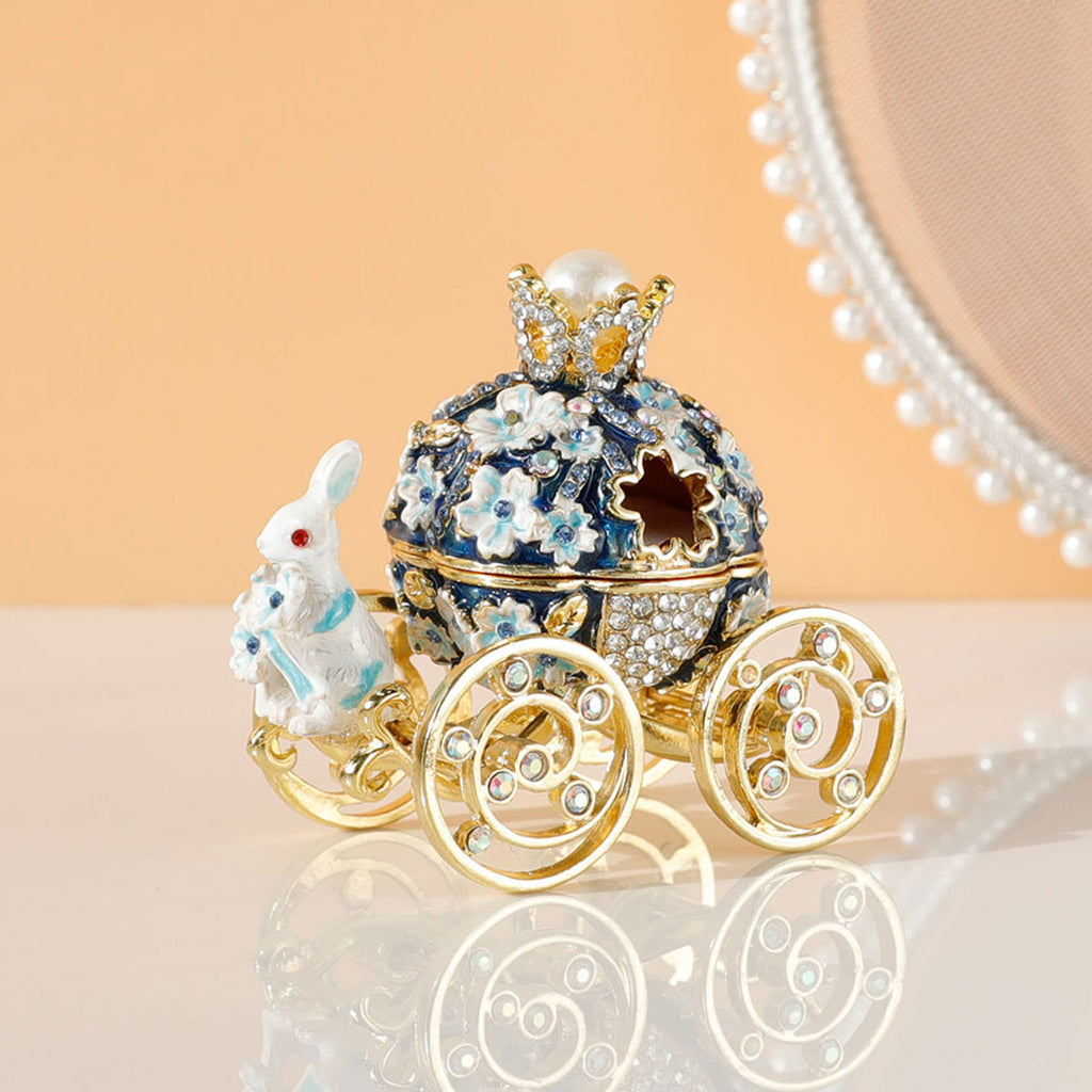Decorative ornament resembling a fairy tale carriage with intricate details on a reflective surface.