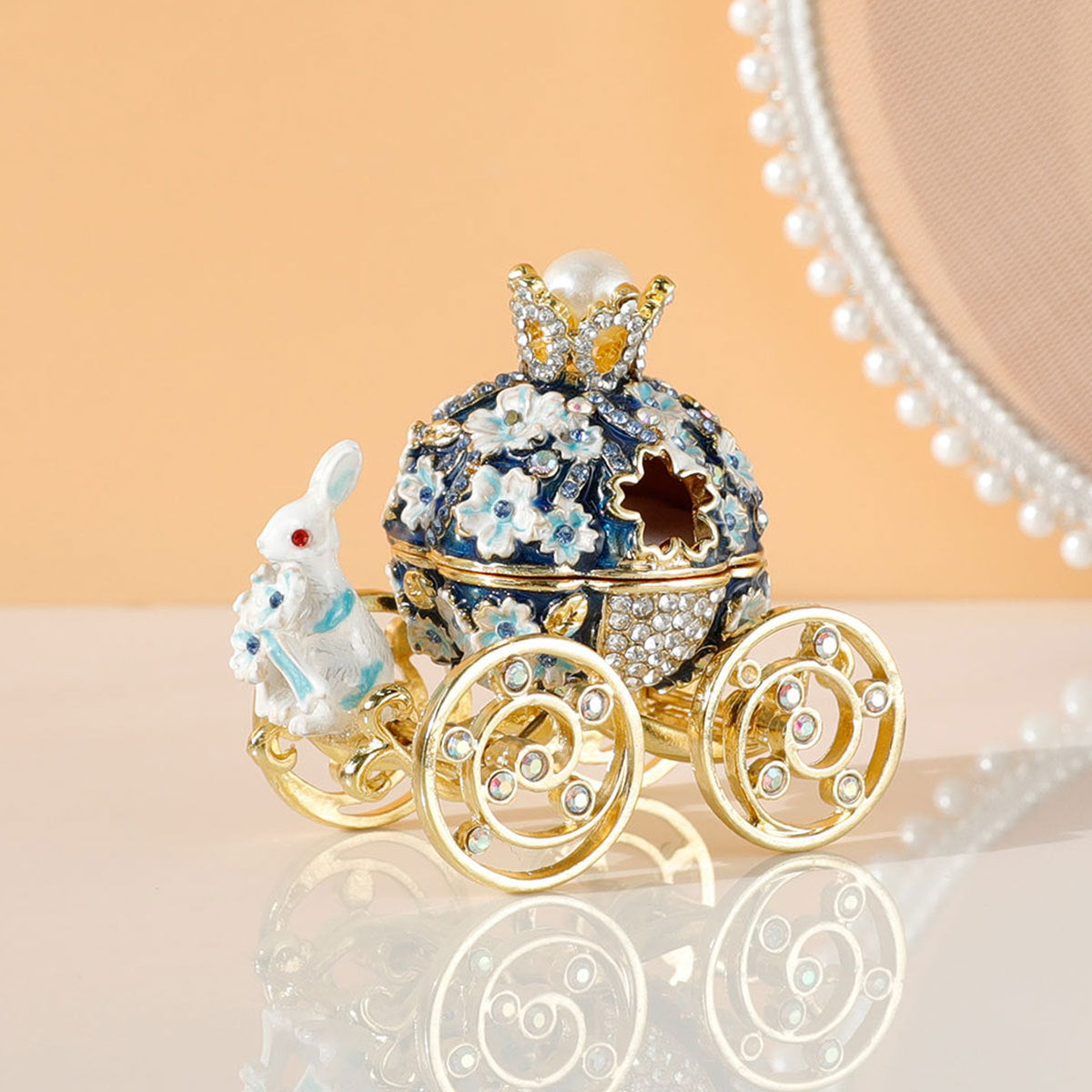 Decorative ornament resembling a fairy tale carriage with intricate details on a reflective surface.