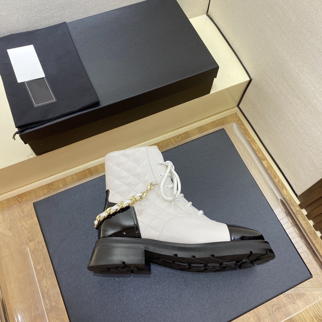White boot with black sole on a blue surface next to a black box.