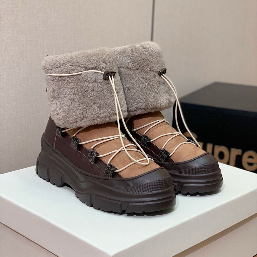 Brown and beige winter boots with fluffy top on a white surface