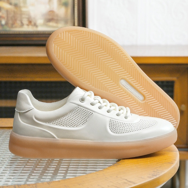 White sneaker with tan sole on a wooden surface
