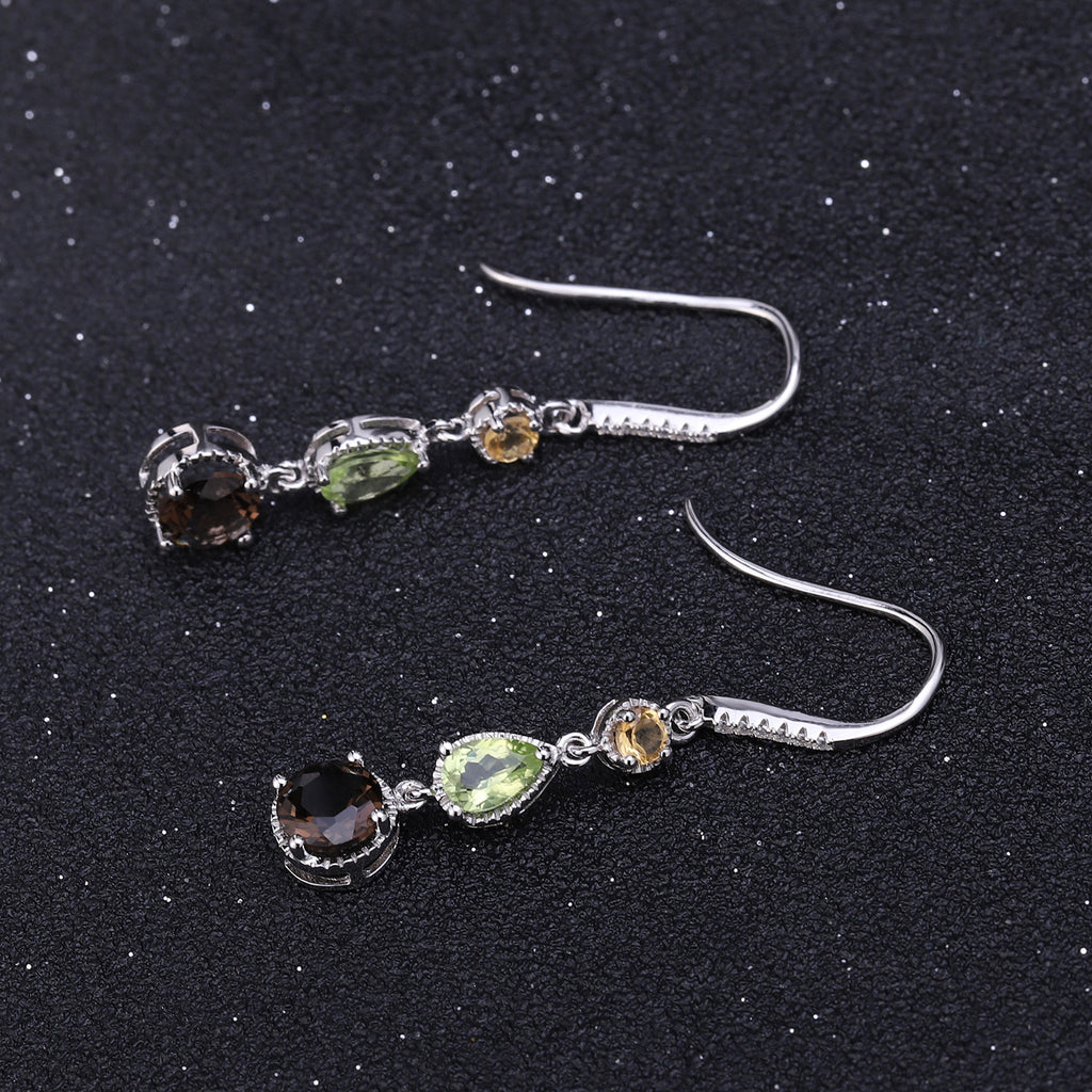 Pair of silver earrings with gemstones on a black background