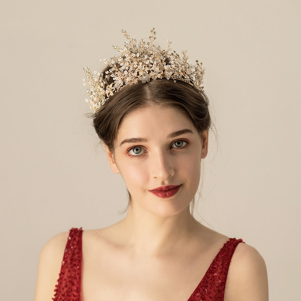 Woman wearing a decorative tiara against a plain background
