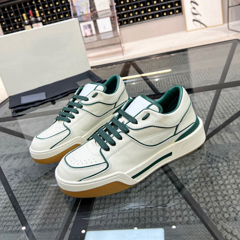 White sneakers with green accents on a glass surface