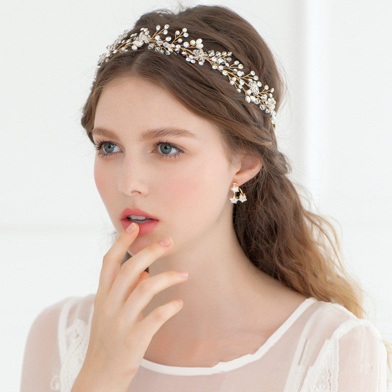 Woman wearing a decorative headband and earrings on a white background