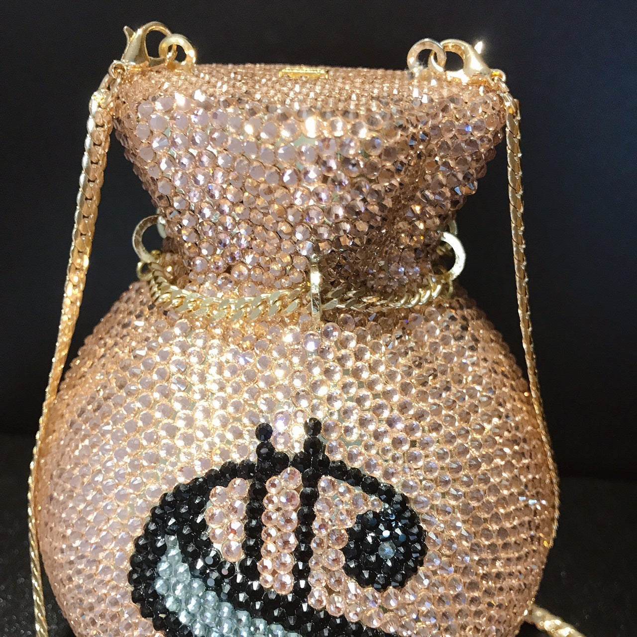 Sparkling handbag with decorative eye design on a dark background