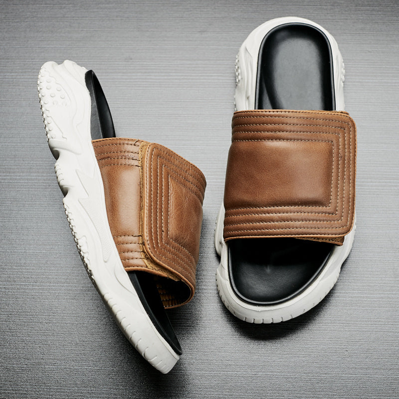 Pair of brown and white sandals on a gray background