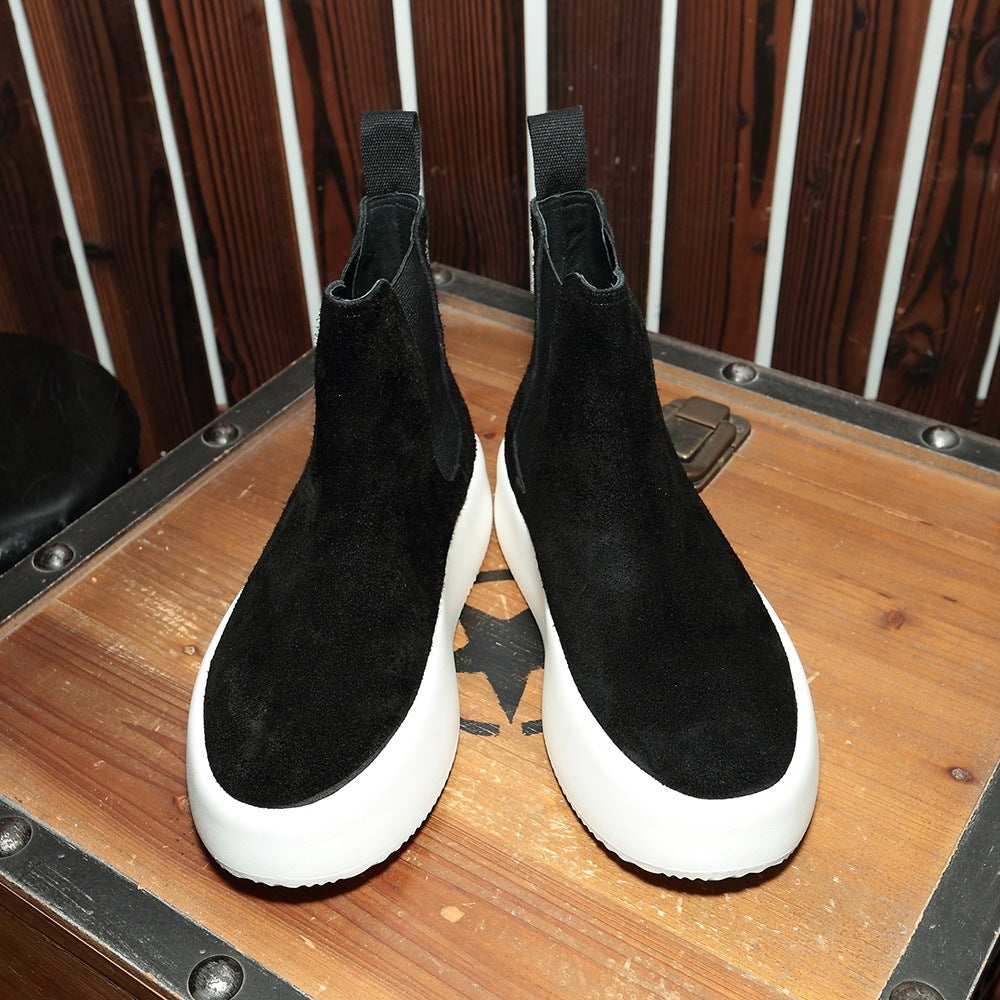 Pair of black and white shoes on a wooden surface with a wooden panel background