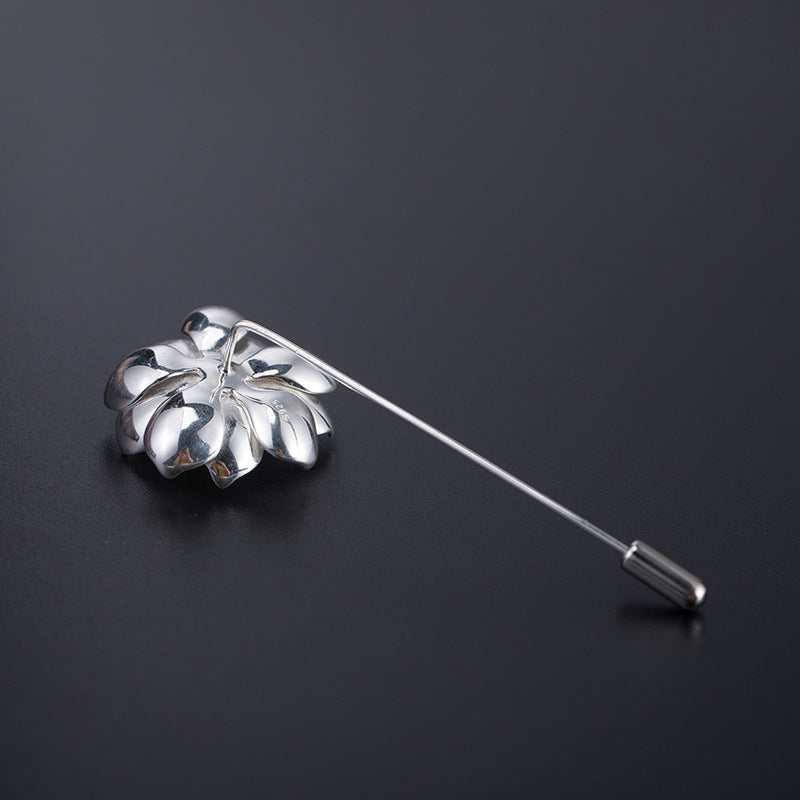 Silver leaf-shaped lapel pin on a black background