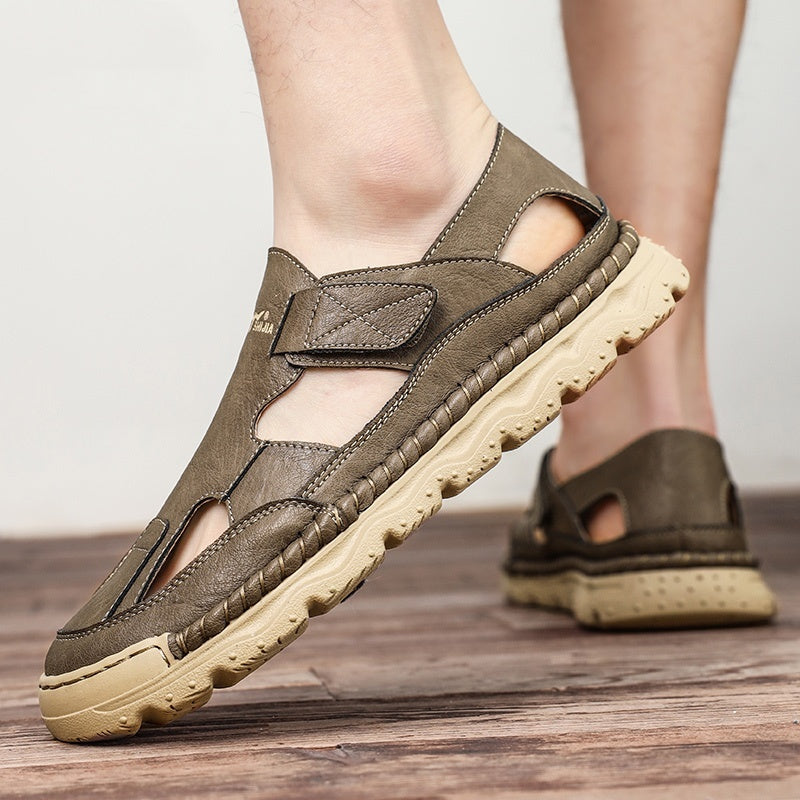 Brown sandals with beige soles worn by a person on a wooden floor.