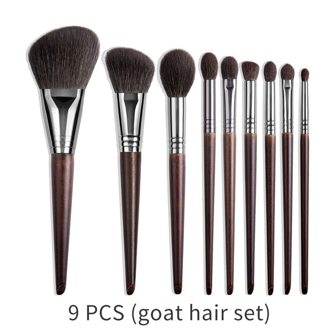 Set of 9 makeup brushes with brown handles and bristles on a white background