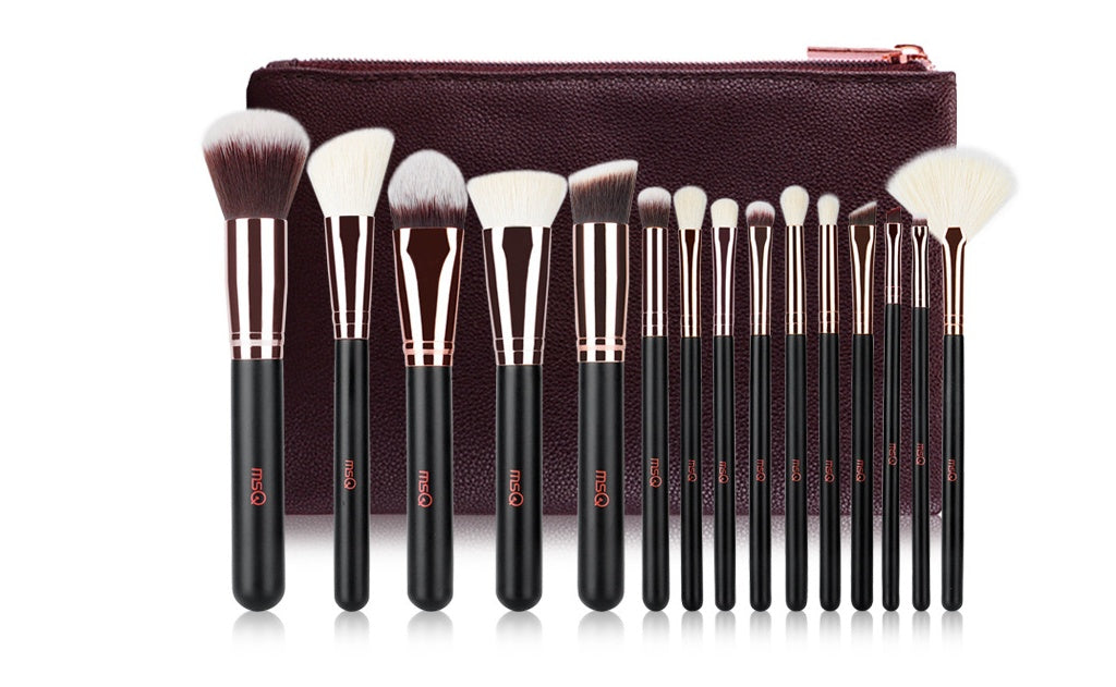 Set of makeup brushes with a brown pouch on a white background