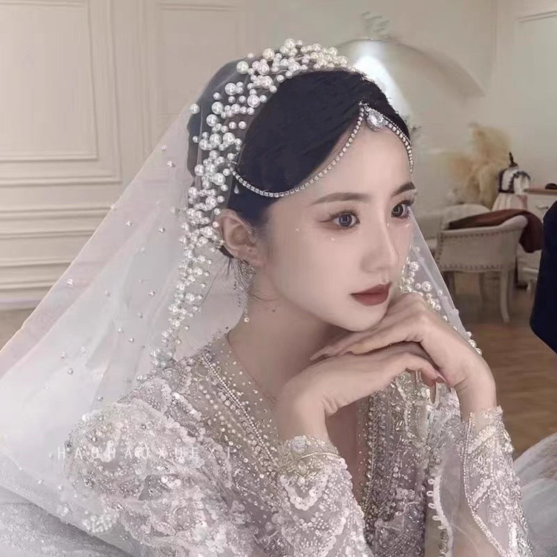 Woman in a wedding dress with a veil and headpiece in an elegant indoor setting