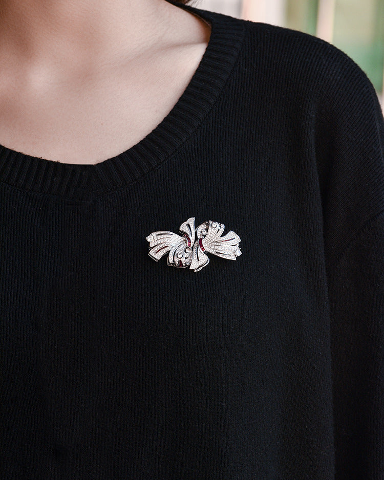 Black sweater with a decorative brooch on a blurred background