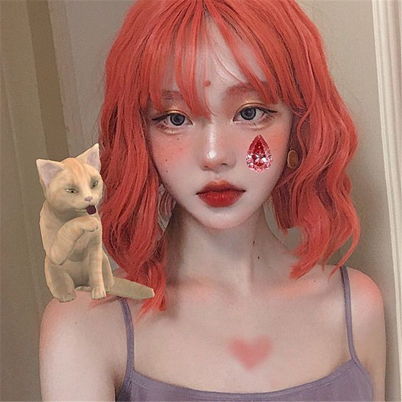 Person with red hair and a small cat figurine next to them