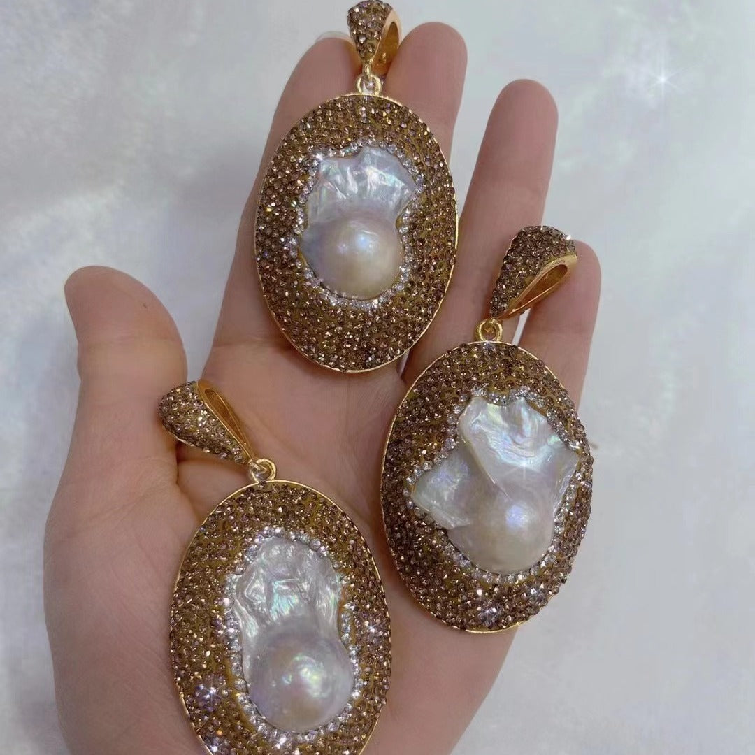 Gold-framed pearl pendants on a hand against a white background