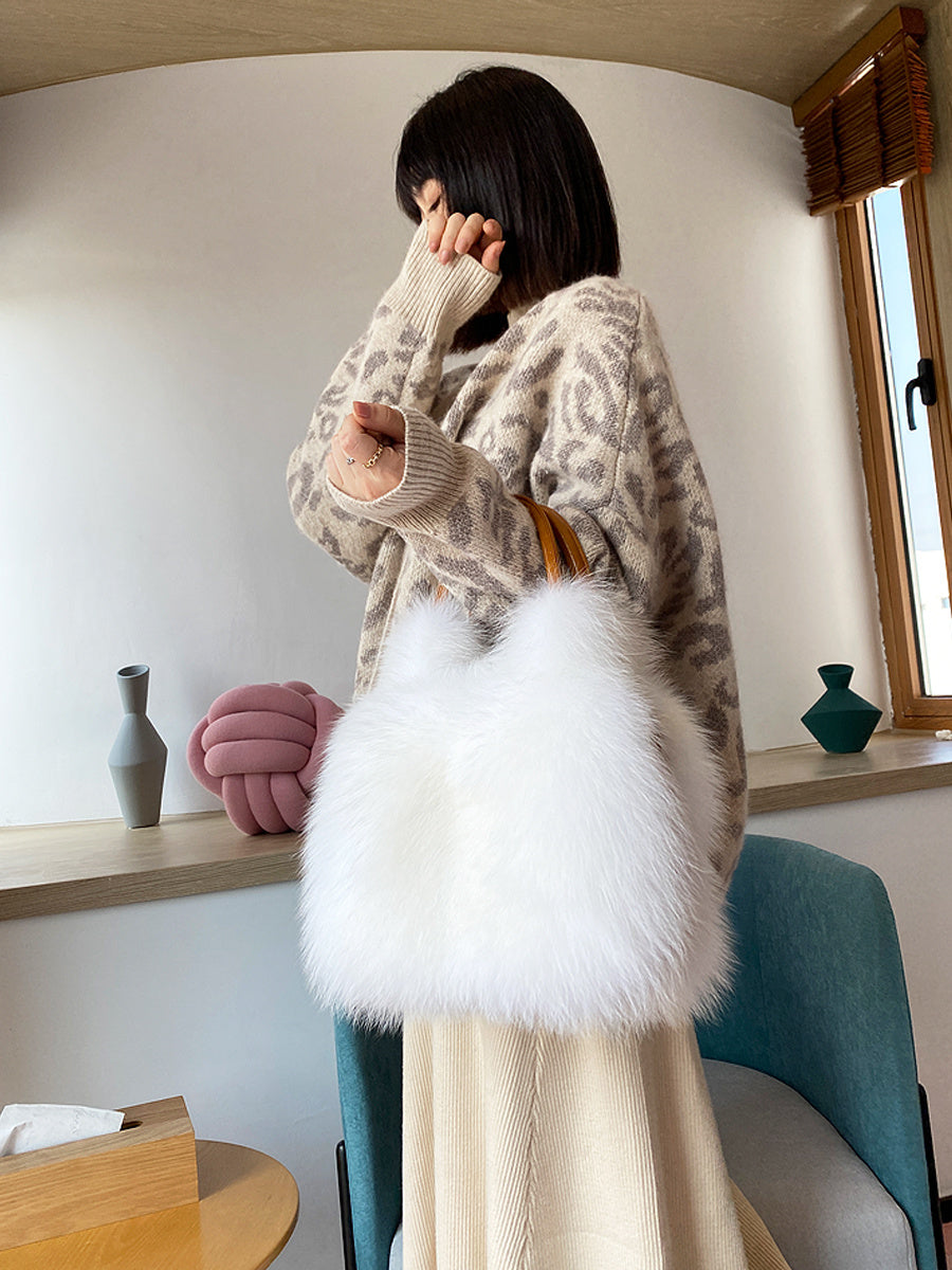 Person holding a fluffy white bag in a room with a window and shelves.