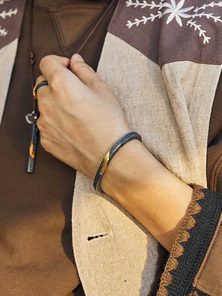 Close-up of a hand wearing a bracelet on a textured fabric background