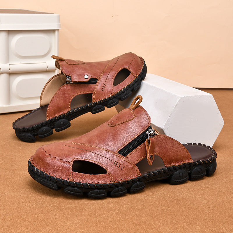 Brown sandals with zippers on a beige surface