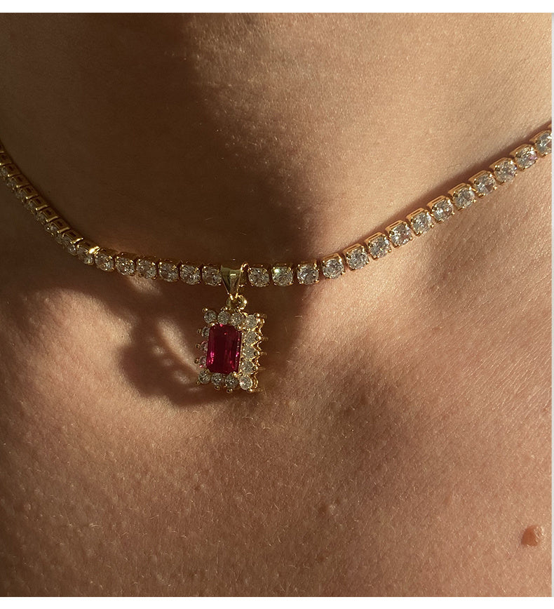 Necklace with a red gemstone pendant on a person's neck