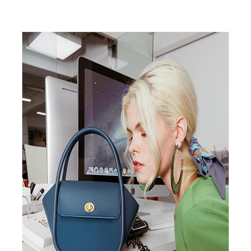 Woman in an office setting with a blue handbag in the foreground