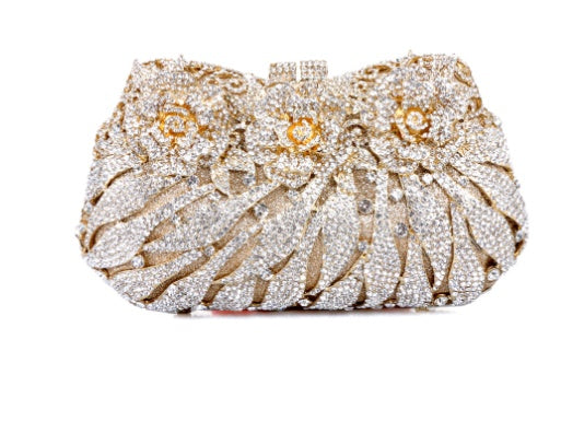 Decorative clutch bag with floral design and rhinestones on a white background