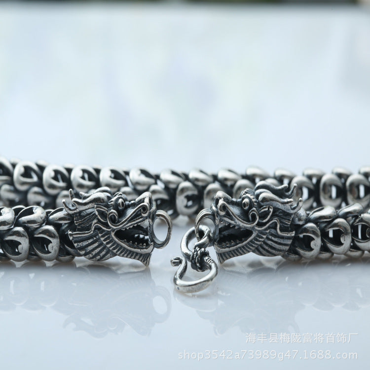 Silver chain with dragon design on a white background