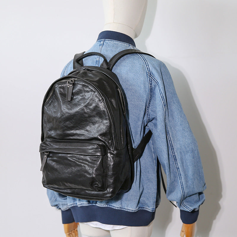 Black backpack on a mannequin with a denim jacket and navy shirt against a white background