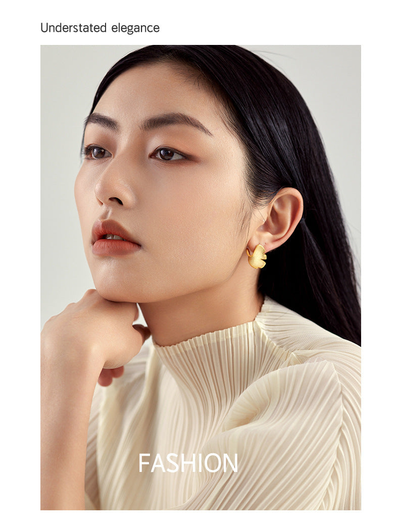 Woman wearing a beige sweater with a neutral background, featuring the word 'FASHION'.