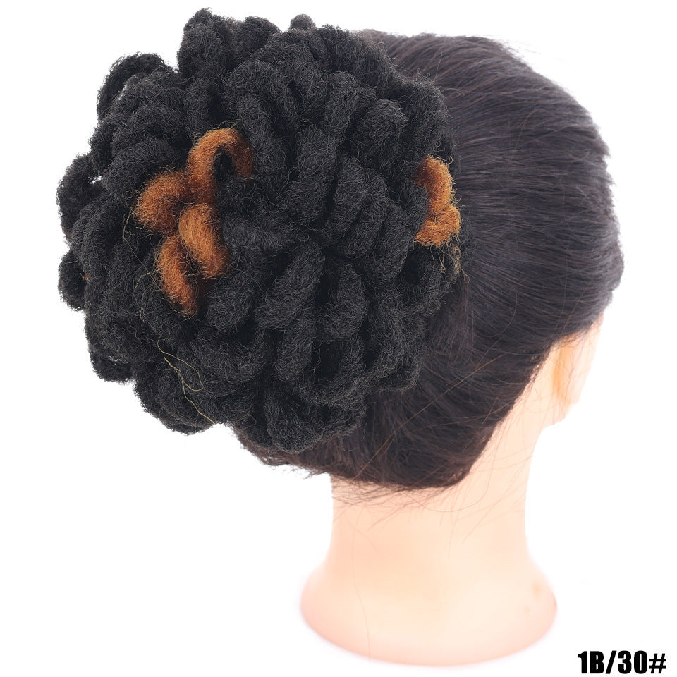 Black flower-shaped hair accessory on a mannequin head with a white background