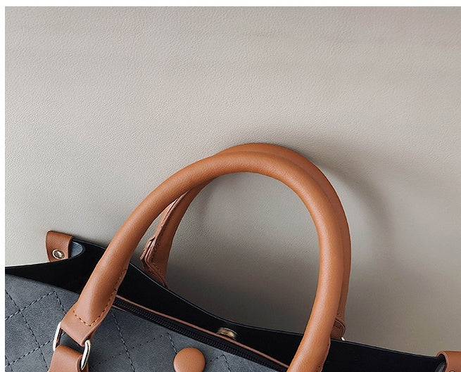 Close-up of a handbag with brown handles on a light gray background