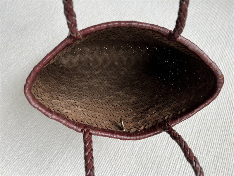 Close-up of a woven basket with braided handles on a light background