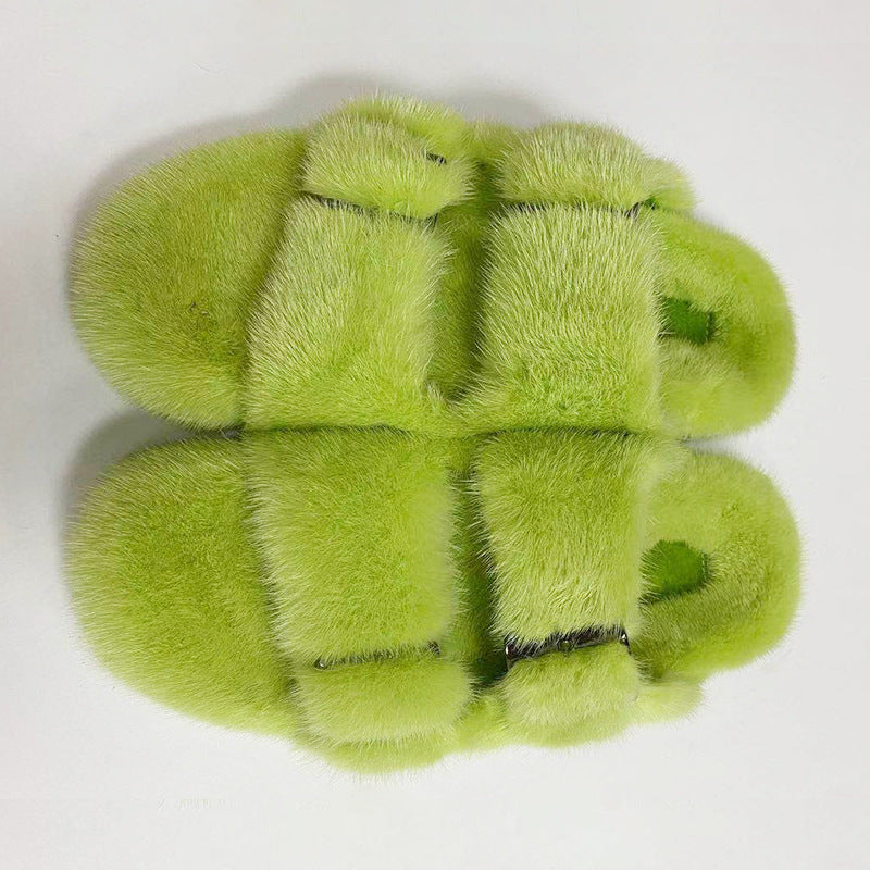 Pair of green fuzzy slippers on a white background