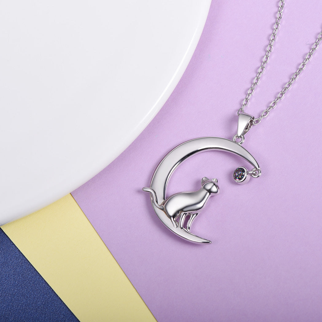 Silver necklace with a cat on a moon pendant on a colorful background