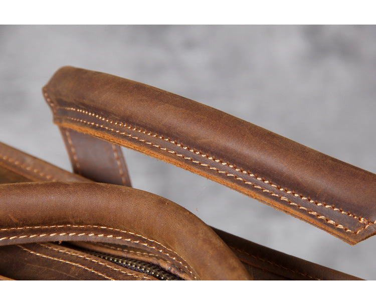 Close-up of a brown leather wallet with visible stitching on a gray background