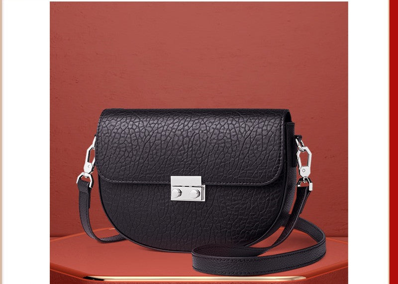 Black leather handbag with silver clasp on a red background