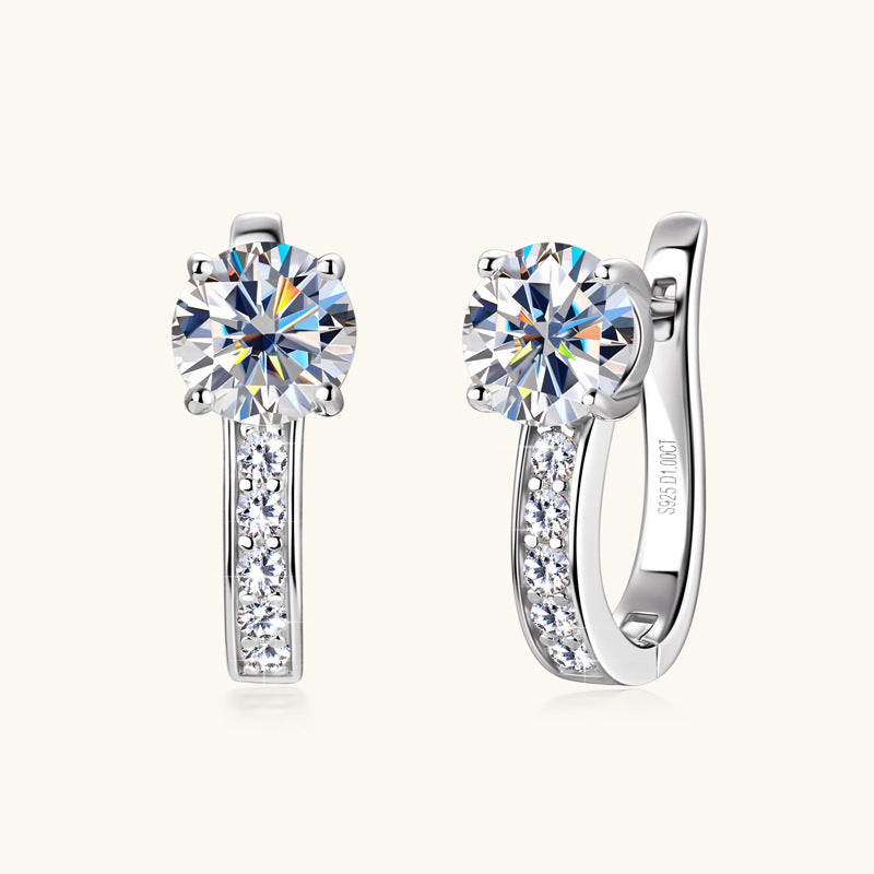 Pair of silver earrings with clear gemstones on a white background