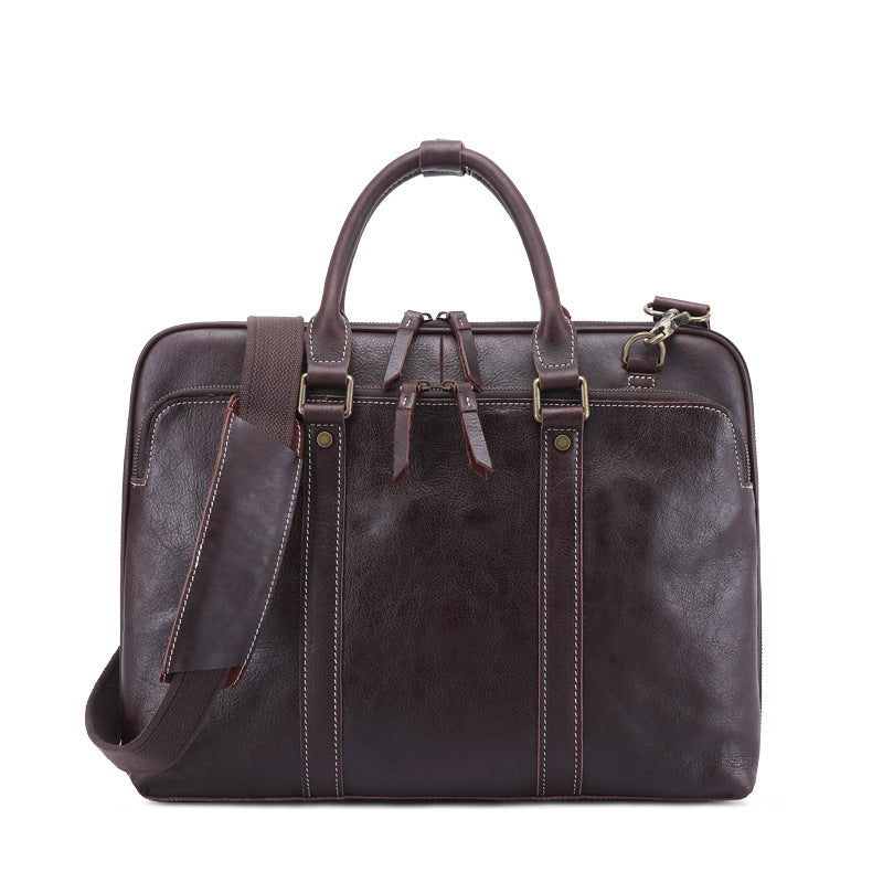 Brown leather briefcase with shoulder strap on a white background