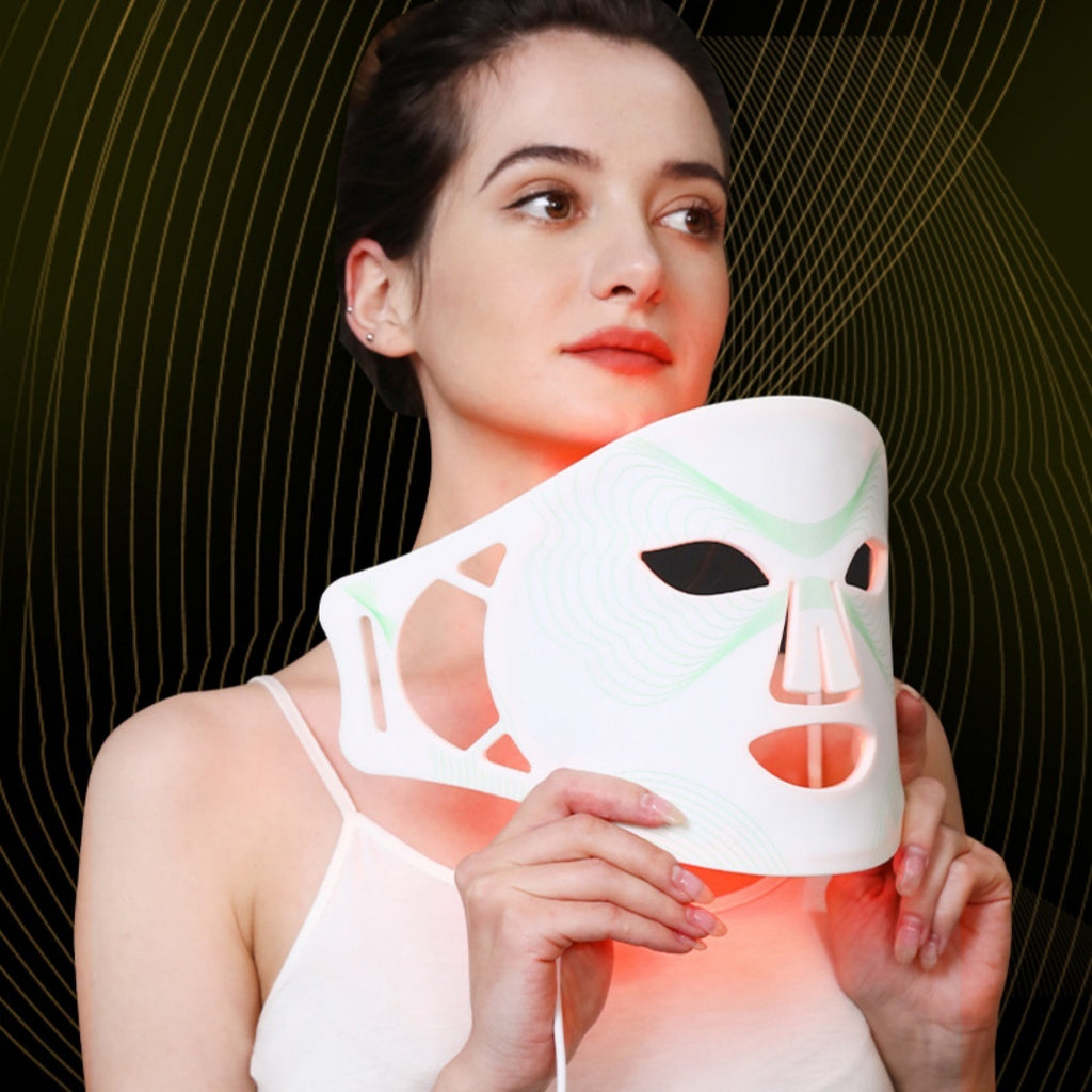 Woman holding a LED face mask with a dark background