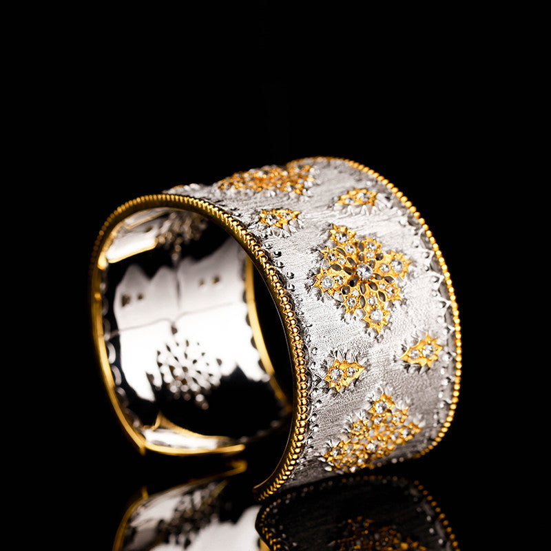 Decorative ring with gold and silver design on a black background