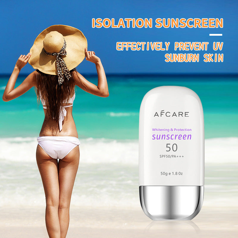Woman in a bikini and sunhat on a beach with an Afcare sunscreen bottle in the foreground.