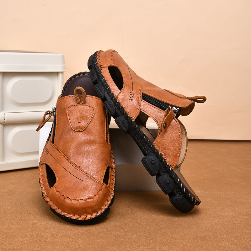 Pair of brown sandals with black soles on a beige surface