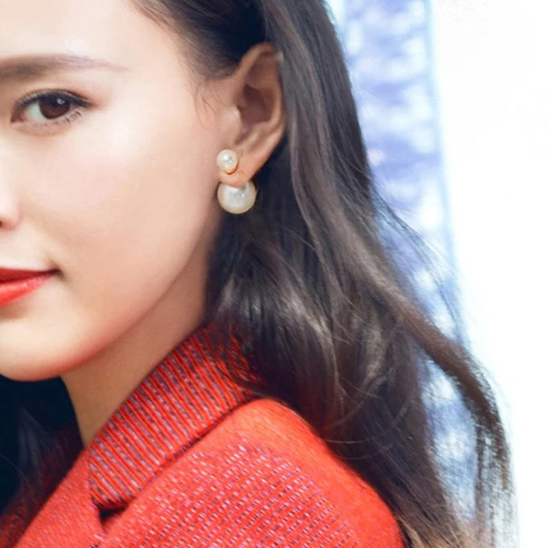 Close-up of a woman wearing pearl earrings with a blurred background