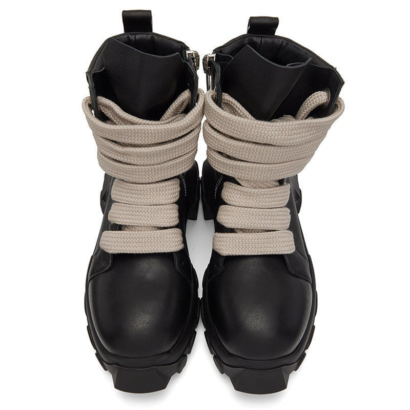 Black boots with beige elastic laces on a white background