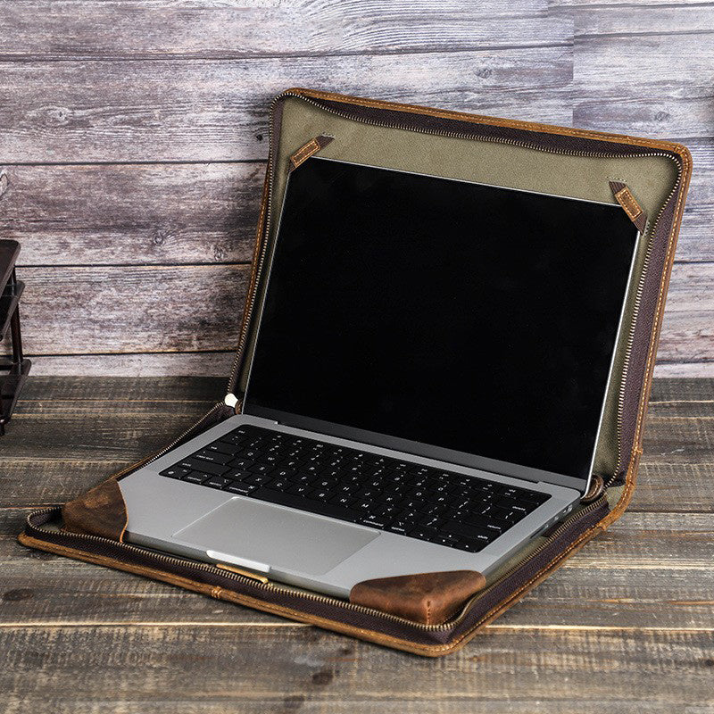 Laptop in a brown leather case on a wooden surface
