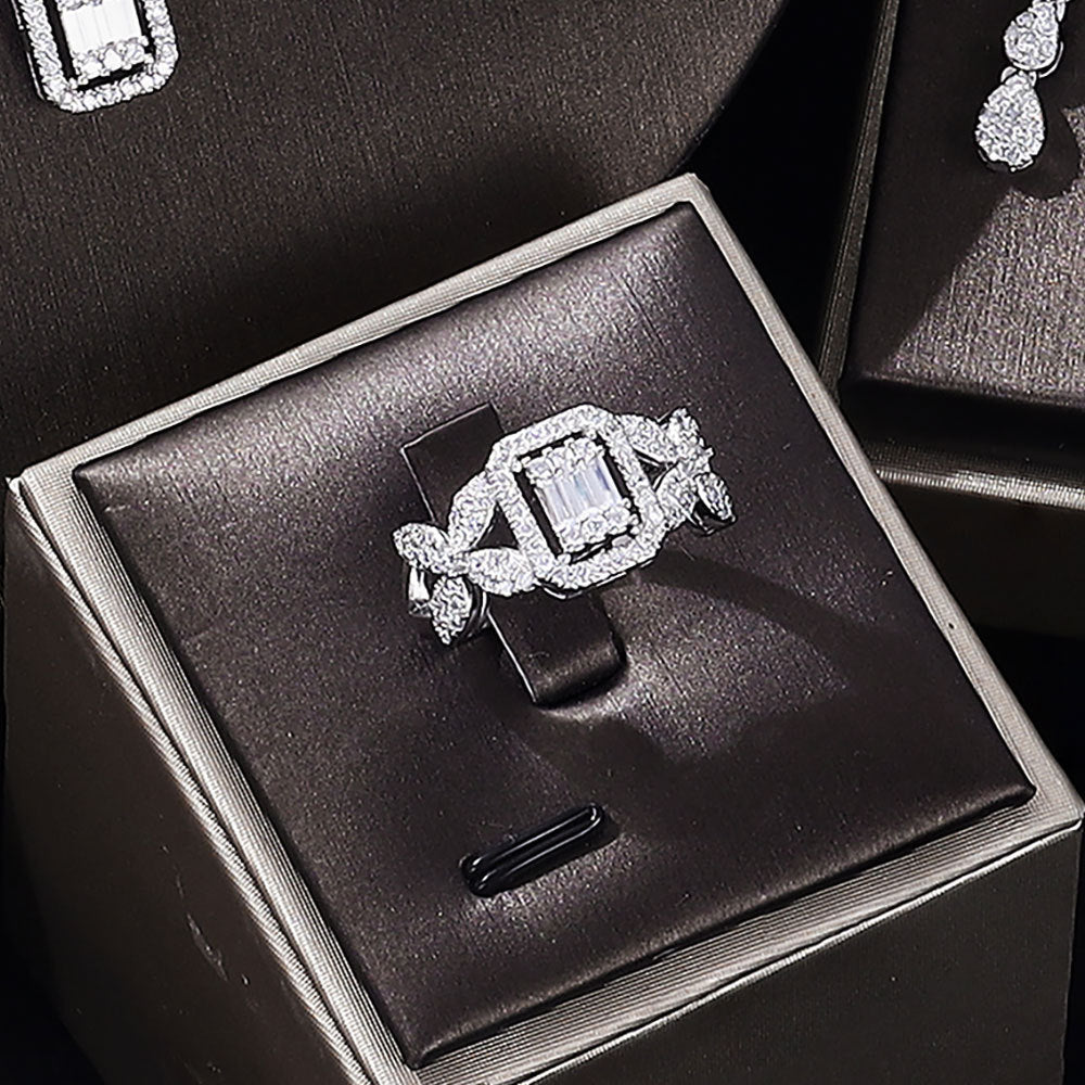 Diamond ring in a black jewelry box with earrings in the background